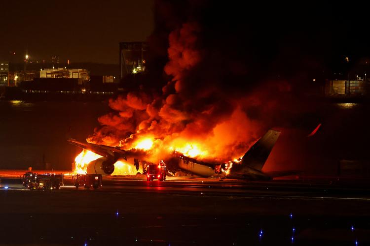 Flyet brød i brand umiddelbart efter landingen og var hurtigt omspændt af flammer. Foto: Issei Kato/Ritzau Scanpix