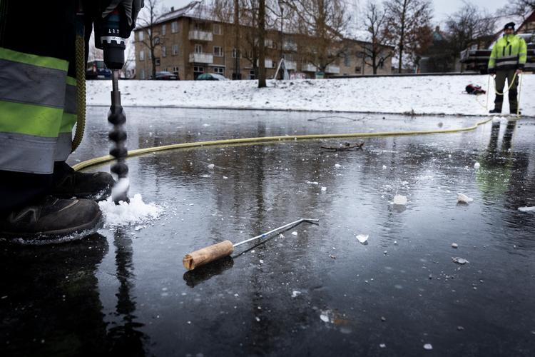 Isen på gadekæret ved Utterslev Torv får en flænge hele vejen på tværs, da gartner Louise Larsen er ved at bore hul. Foto: Emil Bay