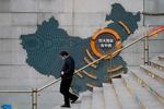 En mand går forbi et kort, som viser Evergrandes bygninger rundt i Kina. Kortet hænger ved en kommerciel ejendom i Beijing, som Evergrande ikke har bygget færdig. Foto: Greg Baker/Ritzau Scanpix