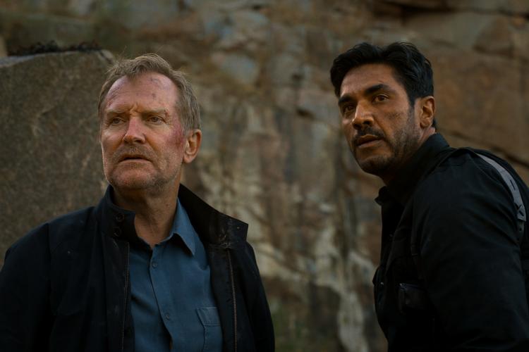 Ulrich Thomsen og Afshin Firouzi som Carl Mørck og Assad på en baggrund af et bornholmsk klippeparti. Foto: Nordisk Film Production
