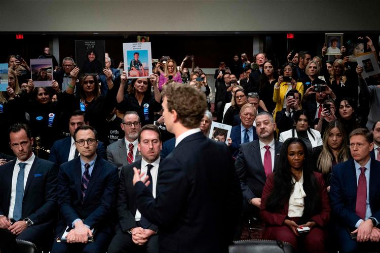Mark Zuckerberg vendte sig om for at sige undskyld til  forældre, som bar skilte af deres børn, der havde været udsat for uønskede sekusuelle tilnærmelser Foto: Brendan Smialowski/Ritzau Scanpix