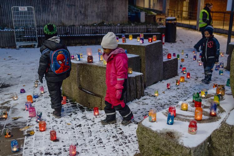 De seneste ti år er bandekriminaliteten blevet værre i Sverige – og nu spreder den sig til Norge. Her, foran metrostationen i den stockholmske forstad Bredäng, har børn og voksne sat lys omkring en stenskulptur for at markere børnenes ret til at føle sig trygge. Foto: Benjamin Krog