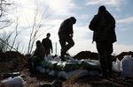 Ukrainske soldater ved en skyttegrav nær Avdijivka, som de måtte opgive at holde i weekenden. Det, der er tilbage af byen, er nu besat af russerne. Foto: Anatolii Stepanov/Ritzau Scanpix