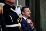 Den franske præsident Emmanuel Macron retter på slipset, inden han tager imod emiren fra Qatar i Elyseepalæet. Foto: Gonzalo Fuentes/Ritzau Scanpix