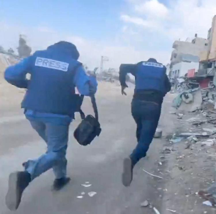 Krigen i Gaza dækkes af lokale journalister. Her ses et billeder af to palæstinensiske journalister på flugt fra eksplosioner.  Foto: Hossam Shabat/Ritzau Scanpix
