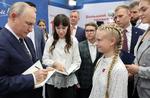 Vladimir Putin skriver autografer ved et besøg på en skole i Moskva-regionen Solonechnogorsk i september.  Foto: Sputnik/Ritzau Scanpix