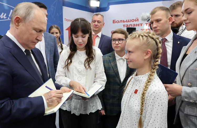 Vladimir Putin skriver autografer ved et besøg på en skole i Moskva-regionen Solonechnogorsk i september.  Foto: Sputnik/Ritzau Scanpix