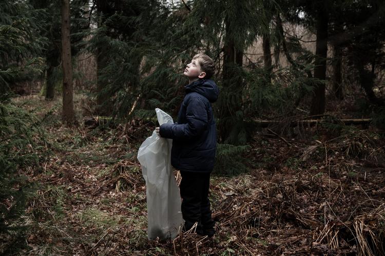 Noget i trætoppene fanger 10-årige Elias opmærksomhed, mens han går tilfældigt rundt mellem grantræerne. Han er med resten af sin klasse i skoven, og han ville ønske, at det oftere var tilfældet. Foto: Nichlas Pollier