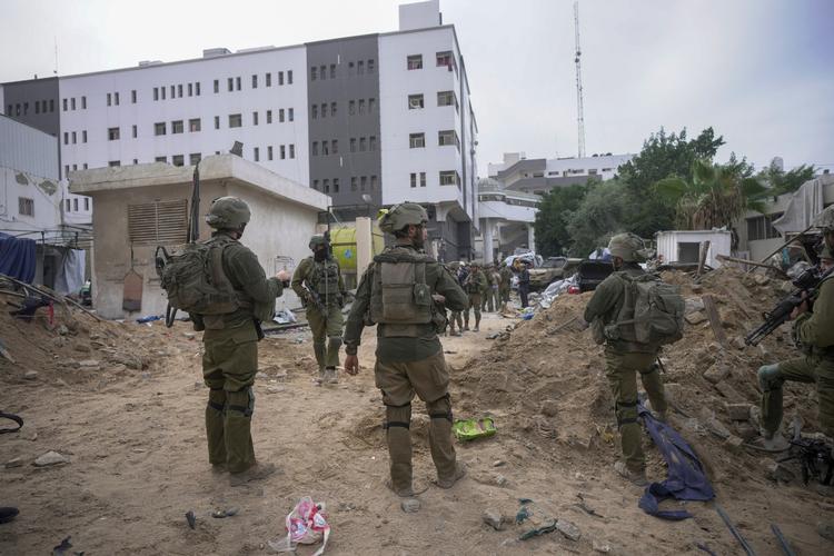 Al-Shifa-hospitalet i Gaza er blevet omringet af Israel, fortæller øjenvidner. Israel hævder, at højtstående medlemmer af Hamas opholder sig på hospitalet. På billedet ses israelske soldater uden for Al-Shifa-hospitalet ved en tidligere lejlighed. Foto: Victor R. Caivano/Ritzau Scanpix