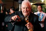 David Seidler tilbyder sin oscarstatuette en drink i 2011.        Foto: Lucas Jackson/Ritzau Scanpix