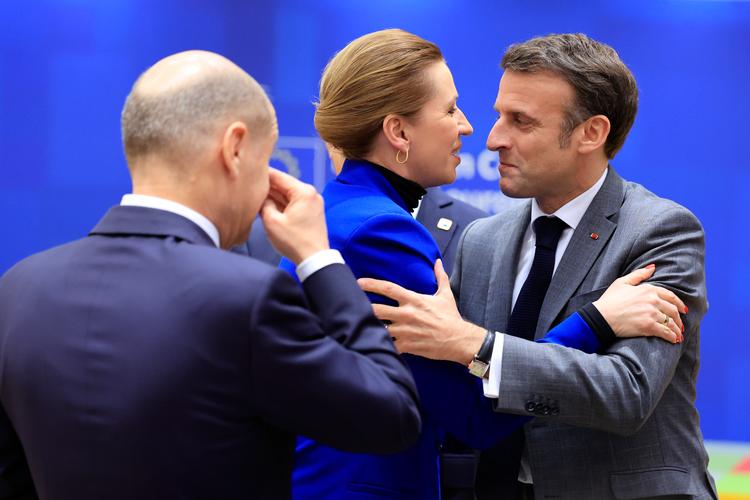 Den franske præsident Macron hilsner på statsminister Mette Frederiksen (S) ved topmødet, mens den tyske kansler Scholz ser på Foto: Geert Vanden Wijngaert/Ritzau Scanpix
