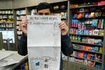 En avissælger i New York holder fredagens udgave af The Wall Street Journal op foran sig. Forsiden af avisen domineres af et hvidt felt som en markering af årsdagen for fængslingen af avisens journalist Evan Gershkovich, der blev anholdt for præcis et år siden og sidder i et russisk fængsel anklaget for at indsamle oplysninger for USA. Foto: Timothy A. Clary/Ritzau Scanpix