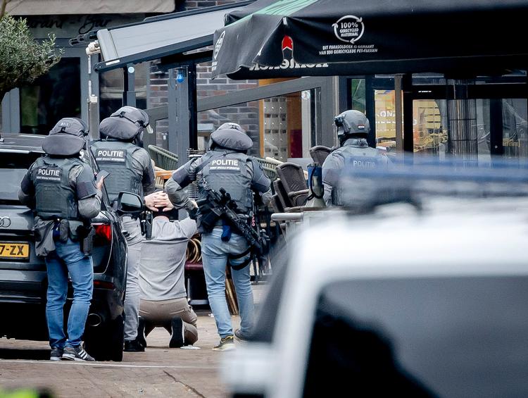Politiets specialstyrker lægger en mand iført elefanthue i håndjern som afslutning på gidselsituation i den hollandske by Ede. Foto: Remko de Waal/Ritzau Scanpix