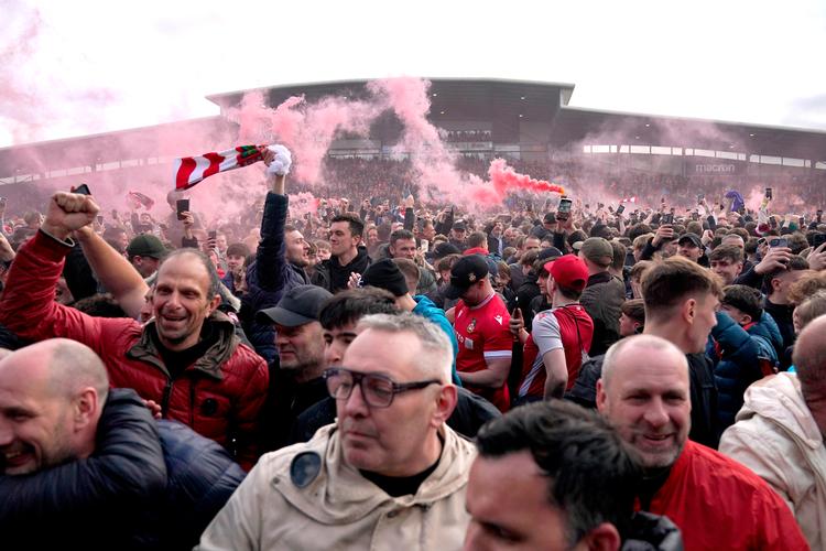 Hundredvis af Wrexham-fans drønede ind på banen, da der var fløjtet af, og det stod klart, at den lille walisiske klub rykker op for andet år i træk. Foto: Jacob King/Ritzau Scanpix