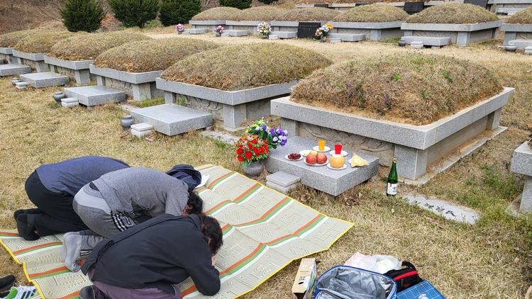 Min kærestes farmor, onkel og far bukker for deres forfader. Bjerget huser kun familiemedlemmer på min kærestes fars side. Foto: Malene Jensen