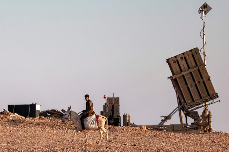 Negev-ørkenen i det sydlige Israel: En dreng på et æsel rider forbi en af de mobile enheder i det såkaldte Iron Dome. Hver af batterierne har 20 missiler.  Foto: Ahmad Gharabli/Ritzau Scanpix