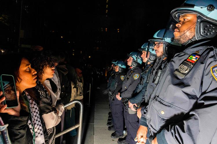 Demonstranter og politibetjente nidstirrer hinanden ved New York University. Foto: Alex Kent/Ritzau Scanpix