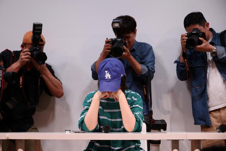 Chefen for pladeselskabet Ador, Min Hee-jin, hulkede flere gange under pressemødet. Imens debatterede netbrugere ivrigt, hvor man kunne købe hendes tøj, og før pressemødet var forbi, var outfittet udsolgt online.  Foto: Kim Hong-ji/Ritzau Scanpix