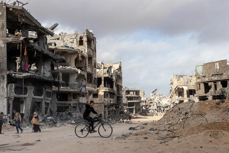 En dreng cykler igennem ødelæggelserne i byen Khan Younis i det sydlige Gaza, efter byen har været under israelsk belejring i omkring to måneder.  Foto: Sacha Myers / Save the Children