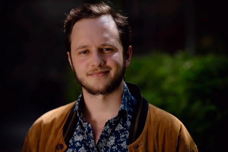 Med skiltet »Jøde, zionist og fan af to stater – lad os snakke sammen« inviterer ph.d.-stipendiat Jonatan Mizrahi-Werner deltagere i den propalæstinensiske teltlejr foran det gamle kommunehospital til dialog i frokostpausen.  Foto: Benjamin Krog