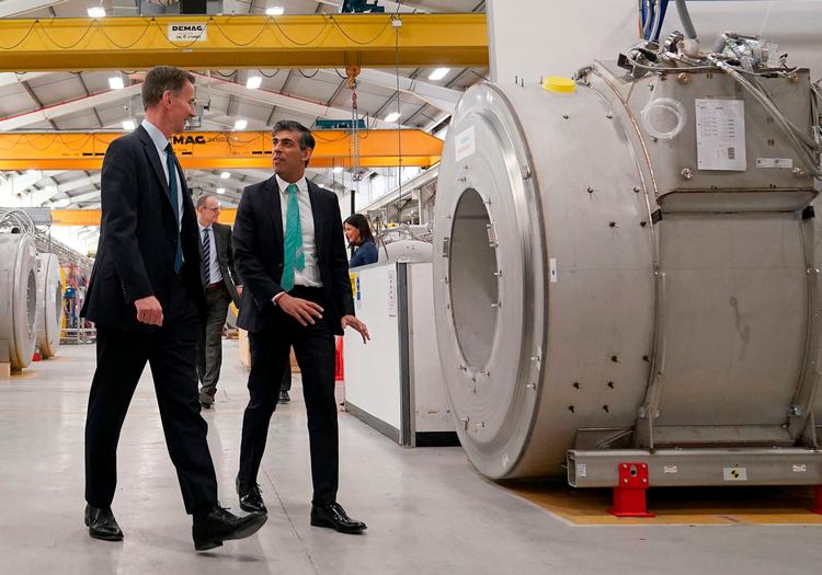 Premierminister Rishi Sunak (th.) og Storbritanniens finansminister, Jeremy Hunt, besøger en fabrik på dagen, hvor nye tal siger, at britisk økonomi er ude af recession. Foto: Jacob King/Ritzau Scanpix