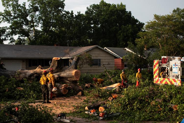 Bransvæsnet fjerner stykker af et væltet træ, der blokerer en gade, efter at en alvorlig storm forårsagede omfattende skader i Spring Branch, Texas, USA. Foto: Kaylee Greenlee Beal/Ritzau Scanpix