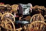 A man reads the latest edition of French weekly newspaper Charlie Hebdo with the title One year on The assassin still on the run on a cafe terrasse in Nice