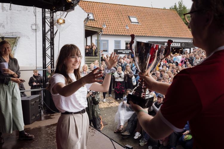 Sofie Mosgaard fra Venstres Ungdom kunne lørdag løfte trofæet og kalde sig Danmarks bedste debattør ved DM i Debat under Folkemødet på Bornholm.  Foto: Emil Bay