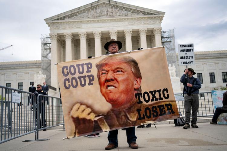 En demonstrant holder et skilt uden for den amerikanske højesteret, mens dommerne hører argumenter om tidligere præsident Trumps påstand om immunitet i forhold til hans bestræbelser på at omstøde resultaterne af præsidentvalget i 2020, 25. april 2024. Foto: Bonnie Cash/Ritzau Scanpix