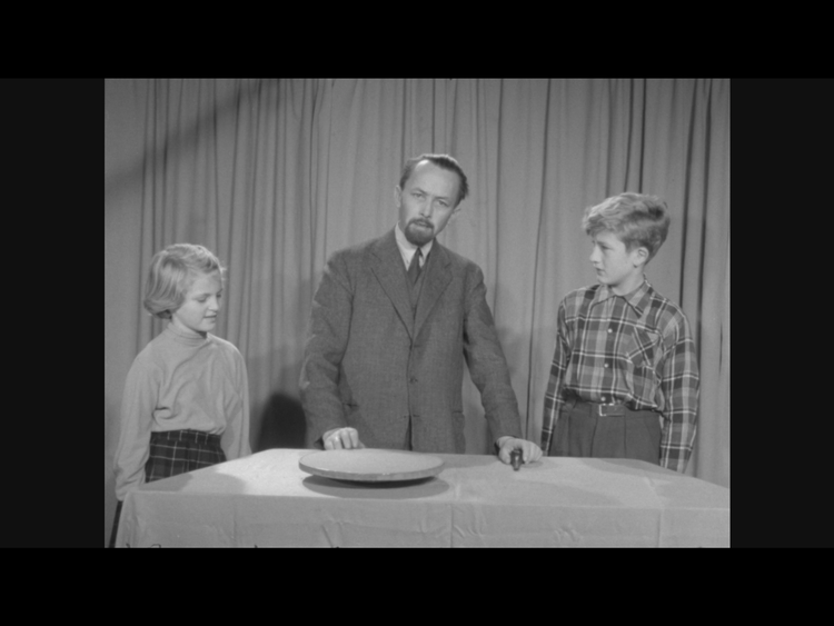 Formidlende børnefjernsyn anno 1954 var en noget alvorstynget affære sammenlignet med, hvad vi er vant til i dag, hvor færre af nutidens medvirkende i Ramasjang har doktorgrader.  Foto: Skærmbillede fra udsendelsen