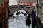 Gondoler passerer igennem Venedigs kanaler, mens de overvåges af en stor gruppe turister. Intet sted i Europa er problematikken om masseturisme mere synlig end i netop Venedig. Foto: Yara Nardi/Ritzau Scanpix