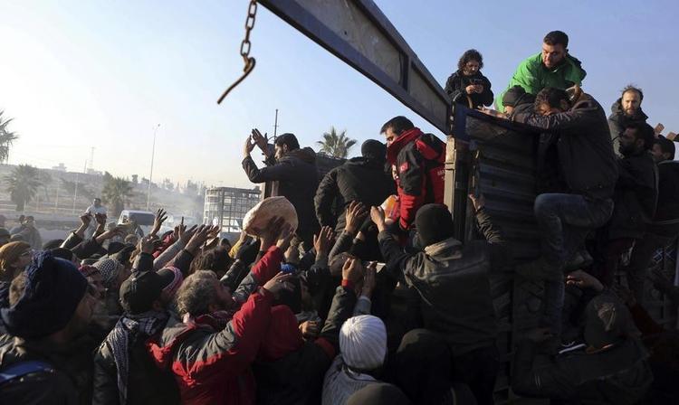Flygtninge fra Østaleppo får brød i nærheden af Idlib. Hvis aftalen mellem Tyrkiet og Rusland holder, er de i dag vågnet op til en våbenhvile  som – hvis den holder – skal føre til fred mellem Assad-styret og en del af oprørerne. 