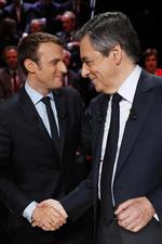 François Fillon (til højre) har slået sig op som en slags oprører i kamp mod eliten, selv om han har været i politik det meste af sit liv. Over for det står den 39-årige Emmanuel Macron, som kommer fra en karriere uden for politik – og i tv-debatten mandag aften slog på netop den forskel. 