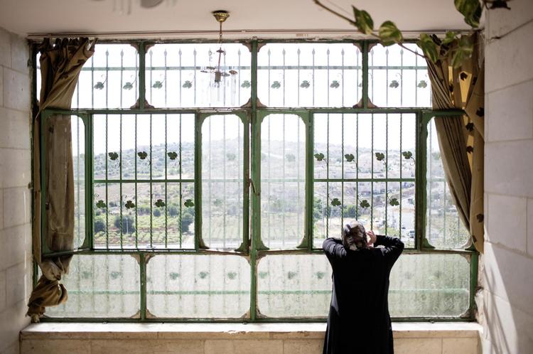 Når Rodayna Jaber ser ud ad vinduet, kan hun se bosættelsen på den anden side af vejen. 