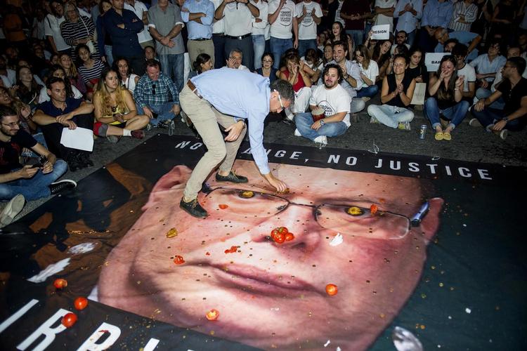 Vrede demonstranter kaster tomater og kager på et billede af politichef Lawrence Cutajar, der beskyldes for at gøre Malta til et mafialand. 