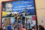 Ungarns regering har iværksat en kampagne mod finans-manden George Soros, som i deres optik har for stor indflydelse. På billedet ses Soros-støtter fjerne en af kampagnens plakater. 