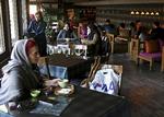 Unge iranere på café i Teheran under en større demonstration for støtte til regeringen som styrets reaktion på protester i mindst 80 andre byer. 