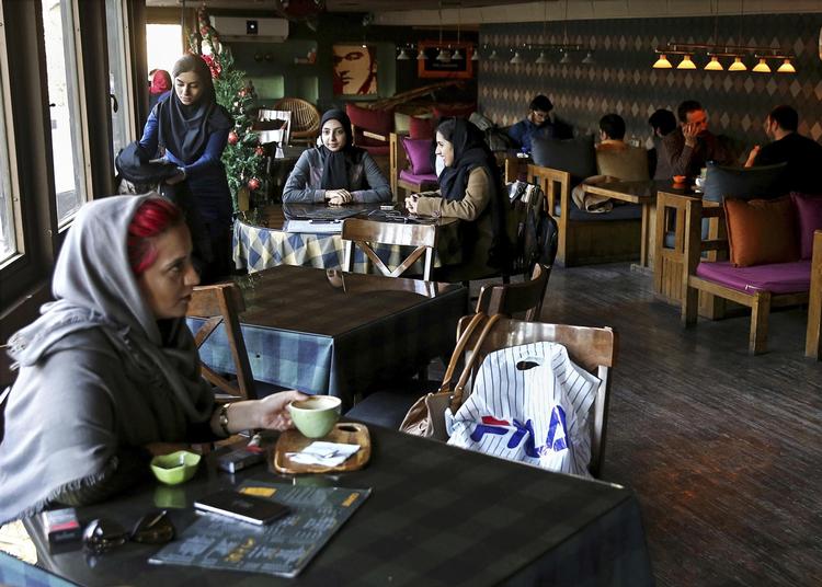 Unge iranere på café i Teheran under en større demonstration for støtte til regeringen som styrets reaktion på protester i mindst 80 andre byer. 