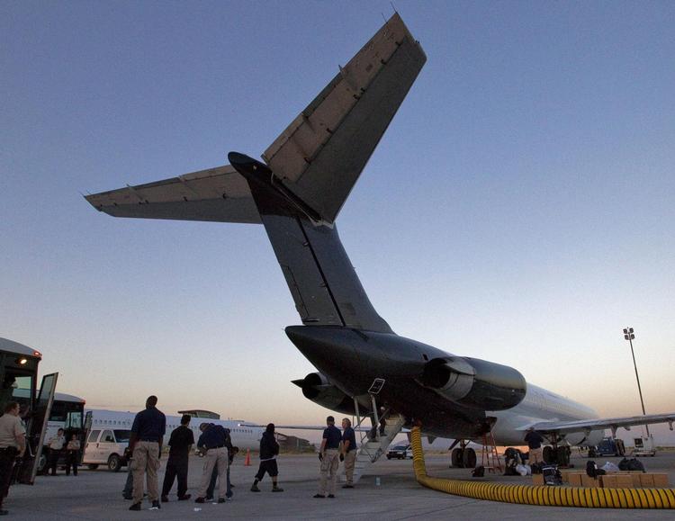 Illegale indvandrere fra El Salvador på vej til at gå om bord på et fly, der i 2012 returnerede dem fra USA til deres hjemland. Arkivfoto Matt York/AP