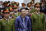 I retten i Hanoi optræder den spinkle Trinh Xuan Thanh kun i selskab med en stor flok mænd i uniformer, som var han en livsfarlig massemorder. 