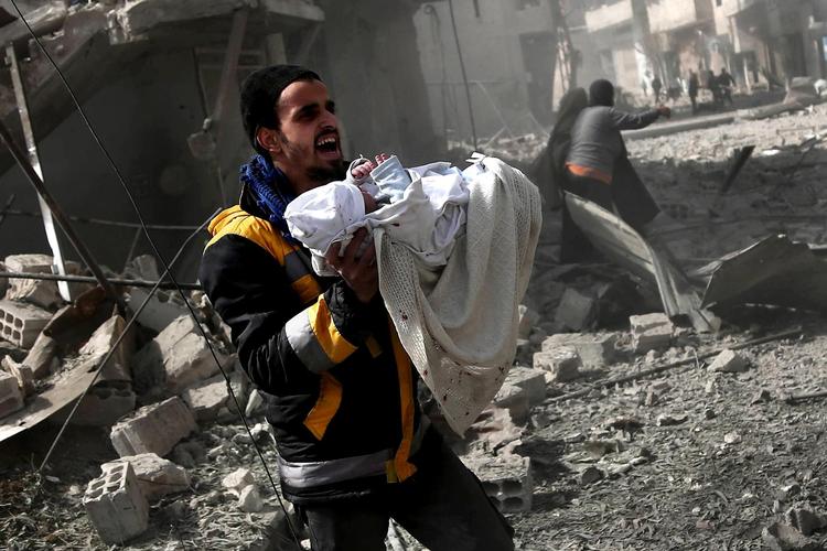 Barnet på billedet er lige blevet reddet ud af ruinerne af en bygning, efter Assads regime angreb byen Ghouta fra luften. Foto Abdulmonam Eassa/AFP/