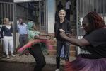 Connie Nielsen  (i centrum) foran Kibera Bycenter, hun har bygget op for at afhjælpe sundhedsproblemer i Nairobis slum. Udviklings- minister Ulla Tørnæs (tv.) er imponeret. Foto Miriam Dalsgaard 