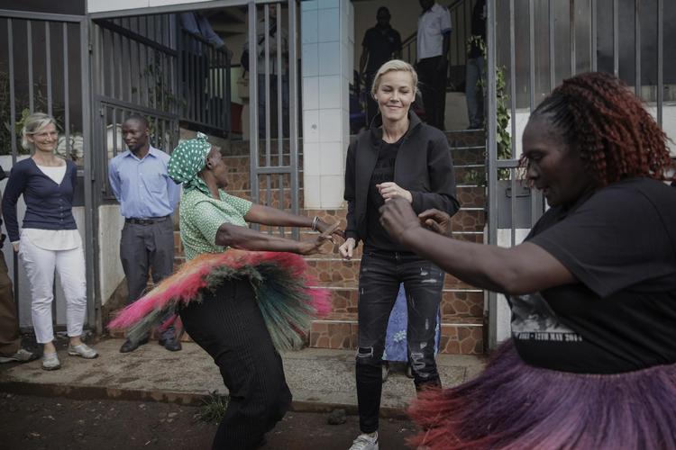 Connie Nielsen  (i centrum) foran Kibera Bycenter, hun har bygget op for at afhjælpe sundhedsproblemer i Nairobis slum. Udviklings- minister Ulla Tørnæs (tv.) er imponeret. Foto Miriam Dalsgaard 
