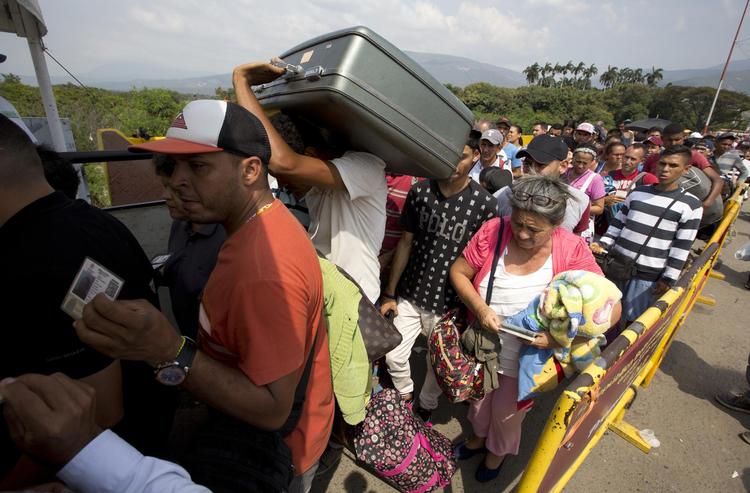 Millioner af venezuelanere er flygtet fra deres hjemland, der er  i dyb krise. Her venter de på grænsen til Colombia. Fernando Vergara/AP