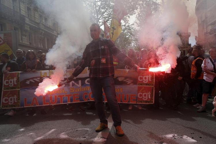 En demonstrant holder et flag under en march mod den nye jern banereform i Frankrig. Reformen er en blandt flere, der i disse dage har skabt utilfredshed mod den franske præsident. Claude Paris/AP/AP