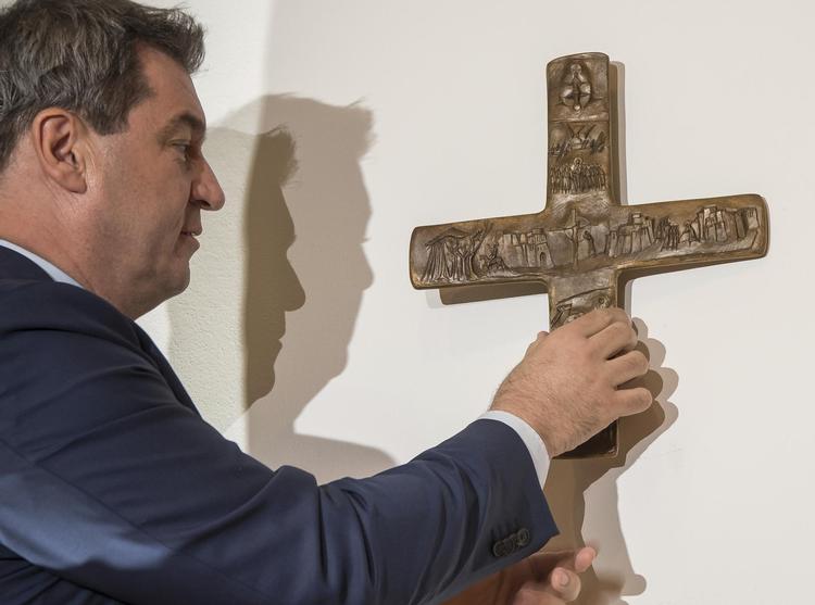 Bayerns politiske leder, Markus Söder, vil indføre krav om synlige kors op hos alle Bayerns offentlige  myndigheder. Her er han ved at sætte  et kors op til indgangen til sine kontorer  i München.  Peter Kneffel/AP