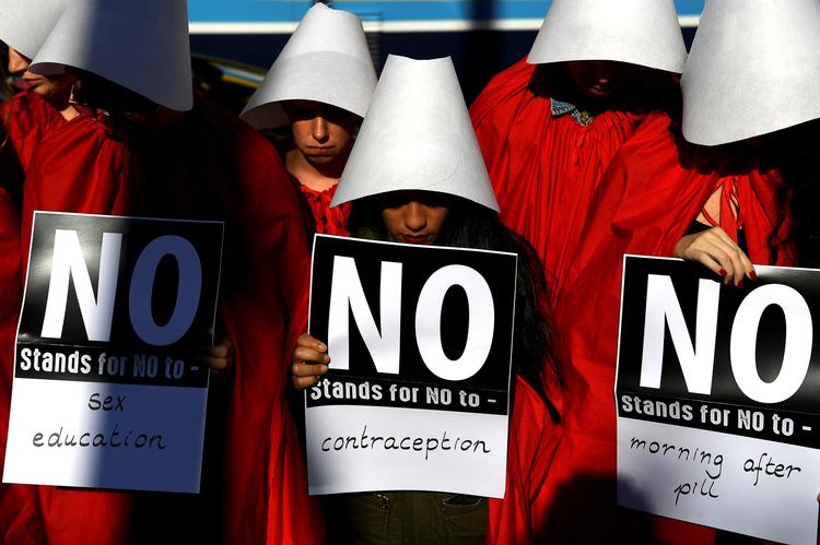 Irske ja aktivister er gået på gaden klædt ud som tjeneste- kvinder fra den amerikanske tv- serie ’The Handmaid’s Tale’, hvor frugtbare kvinder voldtages og tvinges til at føde børn for at sikre kommende  generationer. Til støtte for den modsatte side står folk med billeder af grædende spædbørn og citerer Bibelen. Alle midler tages  i brug.   Clodagh Kilcoyne/Reuters/

