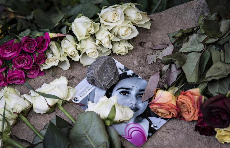 Blomster og et foto af Susanna ligger ved boligblokken i Mainz, som hun aldrig kom hjem til igen. Hun blev myrdet 22. maj. Boris Roessler/AP
