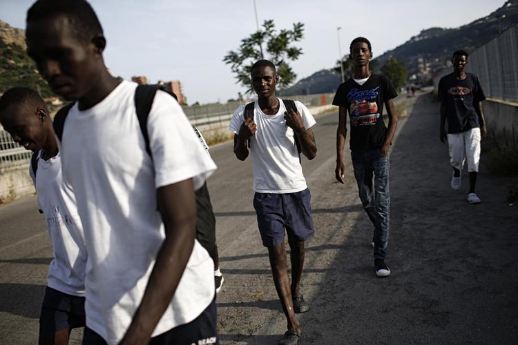Tæt på, men... En gruppe migranter går på en af gaderne i den italienske by Ventimiglia, hvor hundredvis af migranter holder til, inden de forsøger at krydse grænsen til det nærliggende Frankrig, der gør alt for at holde dem ude.  Foto: Marco Bertorello/Ritzau Scanpix /Ritzau Scanpix