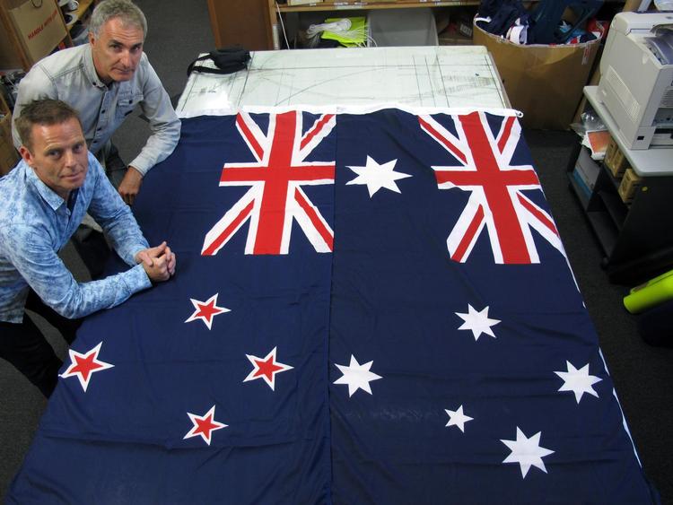 På deres fabrik ved Wellington i New Zealand producerer  Victor Gizzi (tv.) og David Moginie både deres eget lands flag og det australske (th.). Nu er der udbrudt flagkrig mellem de to lande. Arkivfoto Nick Perry/AP